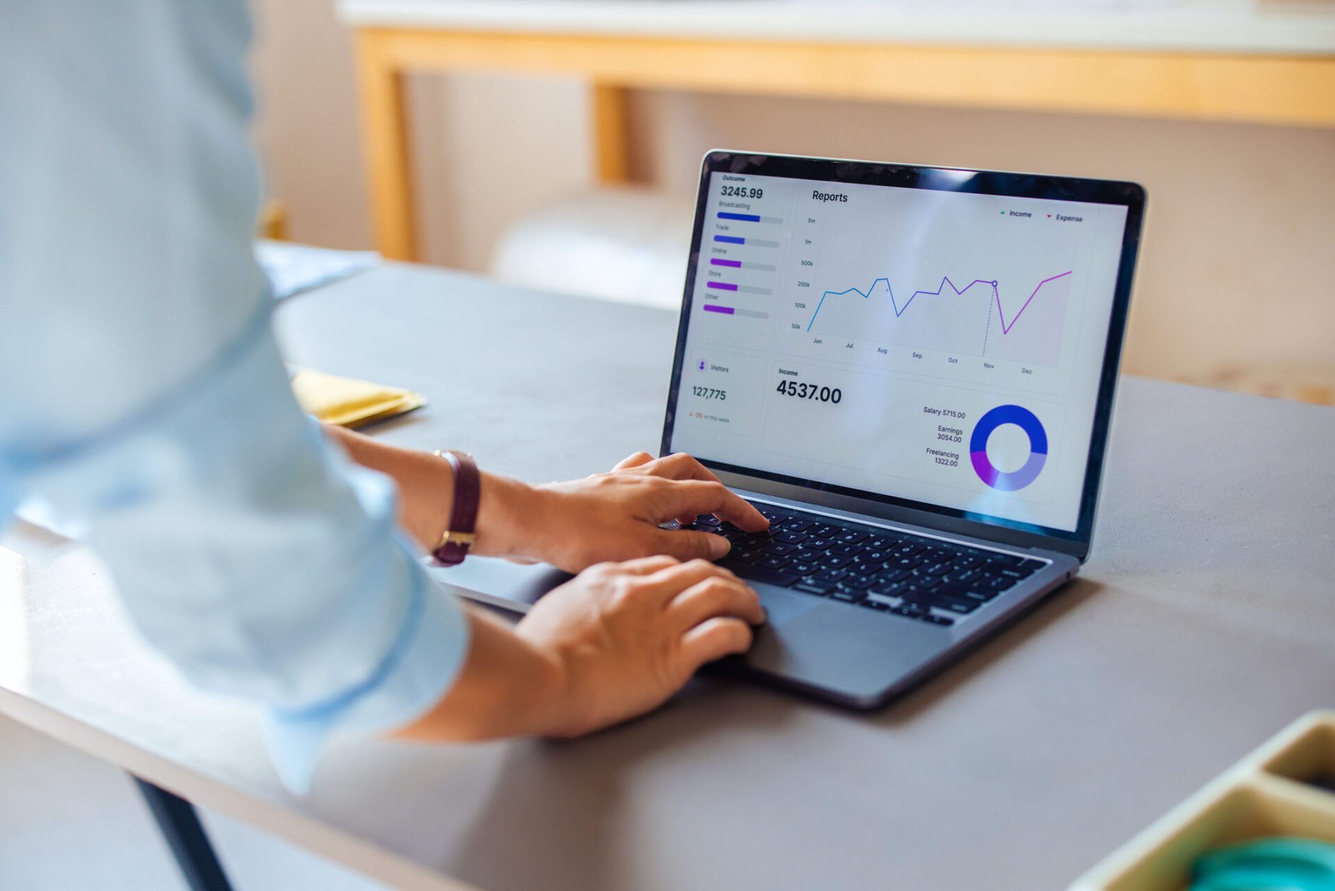Business Professional Analyzing Financial Data on Laptop Person analyzing financial data on laptop with graphs and charts at desk